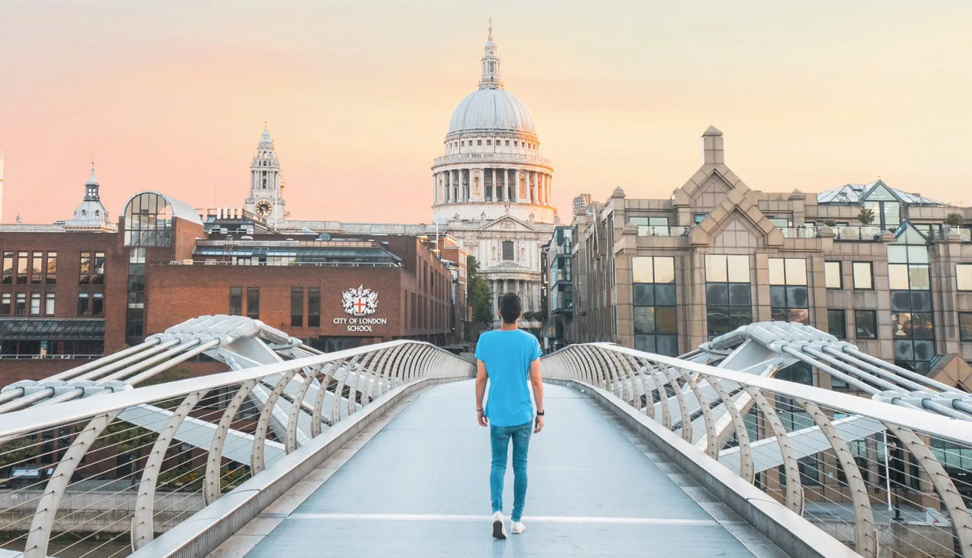 boy walking on the Millenium Bridge towards St Pauls Cathedral and the City of London School for Boys