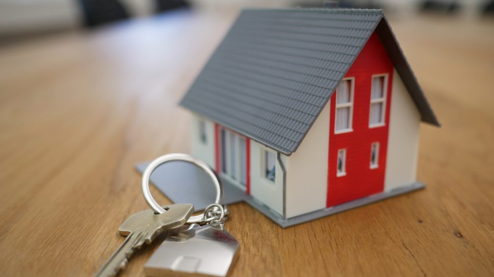 Small play doll house with a set of keys next to it 