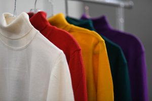 Colourful jumpers on rack